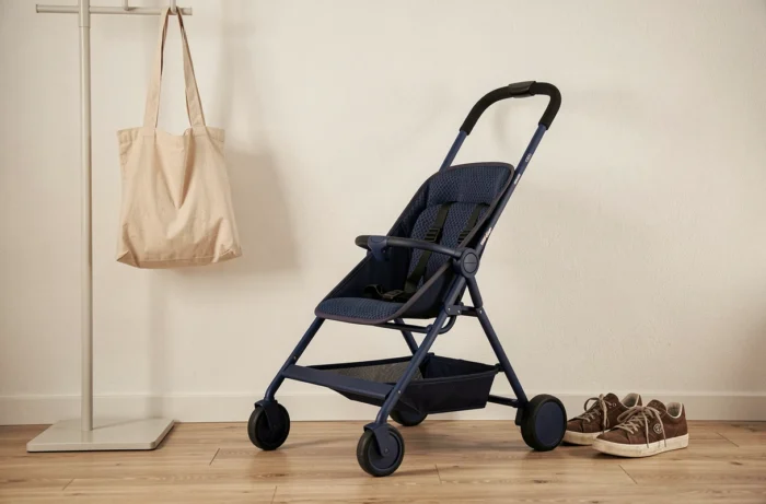 Poussette compacte et légère posée dans une entrée de maison moderne au design minimaliste et épuré